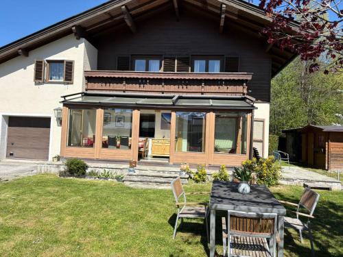 a house with a table and chairs in the yard at Chalet Frieda by Via Montes in Zell am See