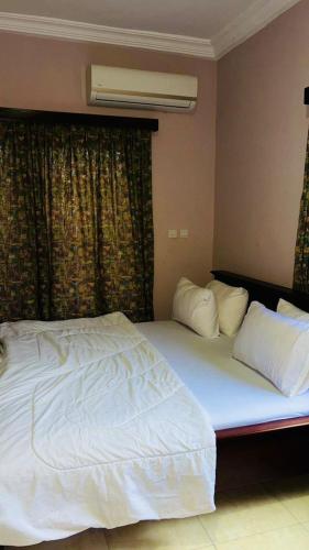 a bedroom with a large bed with white sheets and pillows at AB Home Suites in Asofa