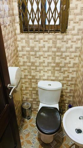 a small bathroom with a toilet and a sink at AB Home Suites in Asofa