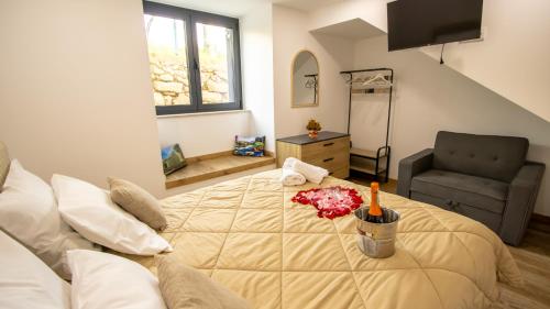 a bedroom with a large bed and a chair at A Casa do Penedo - Arcos de Valdevez in Arcos de Valdevez