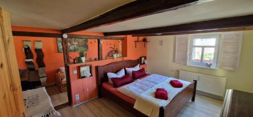 a bedroom with a bed with red pillows on it at Fewo2-Fliegenpilz in Bad Suderode