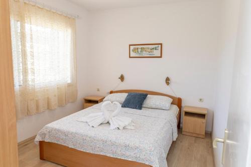 a bedroom with a bed with a white bow on it at Sea View apartment 50 m from St Rok Beach in Pučišća