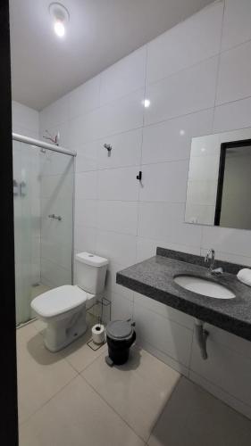 a bathroom with a toilet and a sink and a shower at Golden Silver UNIQUE in Curvelo