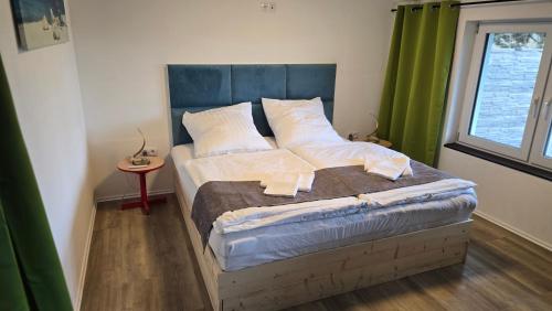 a bedroom with a large bed with a green curtain at Relax House in Dommitzsch