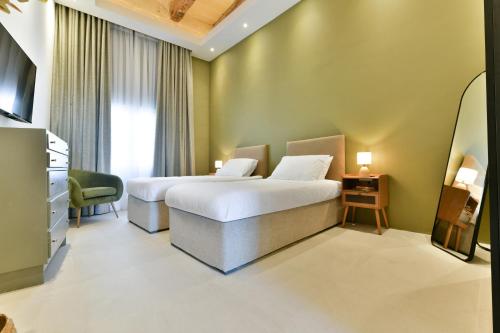 a hotel room with two beds and a television at Xewkija Ta' L-Ghagin in Xewkija
