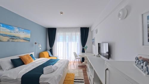a bedroom with blue walls and a bed and a desk at Cozy Studio Olimp in Olimp