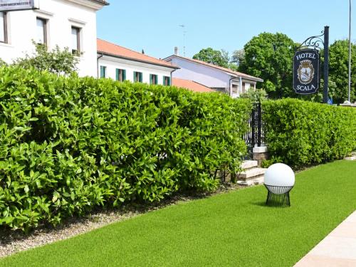 a golf ball is sitting on the grass in front of a hedge at Hotel Scala - Buongiorno! Hotels in Treviso