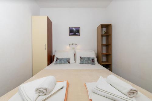 a bedroom with a bed with towels on it at Apartments with parking space Zavala, Hvar - 8710 in Jelsa