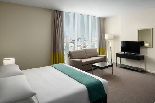 a hotel room with a bed and a chair at Staybridge Suites Al Khobar by IHG in Al Khobar