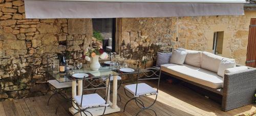 a living room with a couch and a table at La cazelle, dependance du 18 siecle, jacuzzi in Carsac-Aillac
