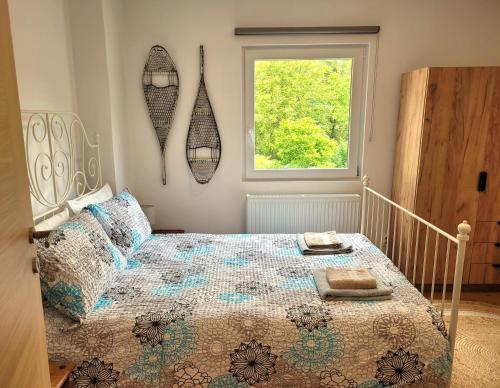 a bedroom with a bed with a comforter and a window at Chalet Julian in Žaga