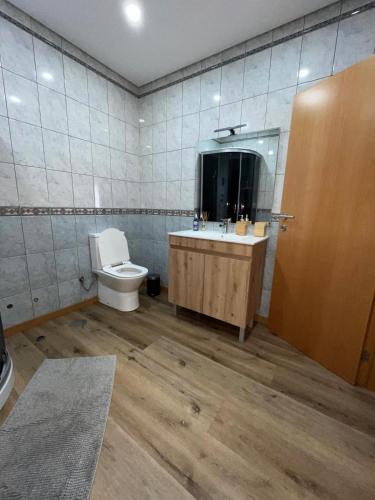a bathroom with a toilet and a sink and a mirror at Préfacio Do Silêncio in Godinhaços