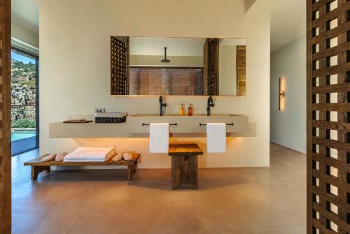 a bathroom with a sink and a bench at Klay Hotel Faralya Adults Only in Faralya