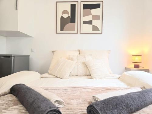 a bedroom with two white beds with pillows at Le Cocon Signature in Château-Thierry