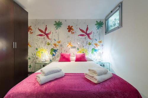 ラスパルマス・デ・グランカナリアにあるSuites Garden Loft Velázquezのベッドルーム1室(ピンクの枕が付いた大型ピンクベッド1台付)