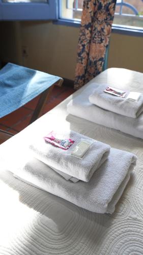 three towels sitting on top of a bed at Posada del Angel in Colonia del Sacramento