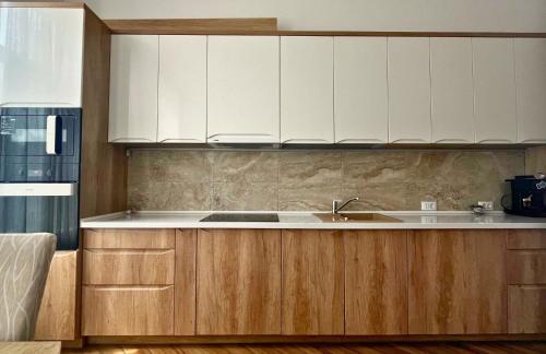 a kitchen with white cabinets and a sink at Fuchsl Palace Grand Suite - Ultra Central in Oradea