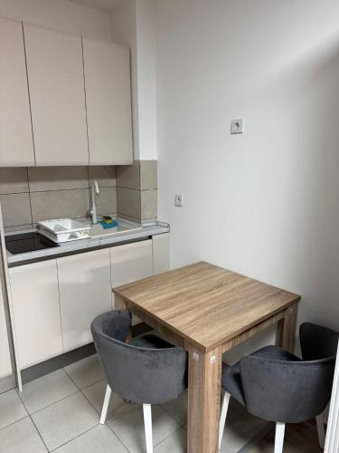 a kitchen with a wooden table and two chairs at Apartman Mila in Trnava