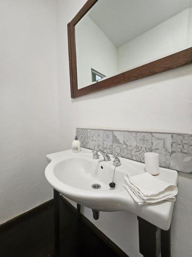a white sink in a bathroom with a mirror at Le Chapitre Français 3 in Rochechouart