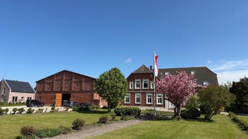 a house with a flag in the middle of a yard at Backhuus 3 in Fehmarn