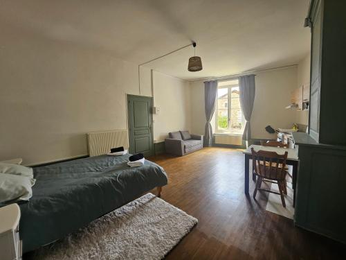 a bedroom with a bed and a desk and a chair at Le Chapitre Français 3 in Rochechouart