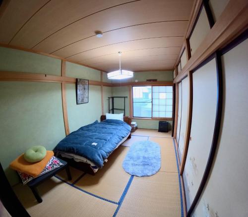 a bedroom with a blue bed in a room at Tsumugu dom in Ueda