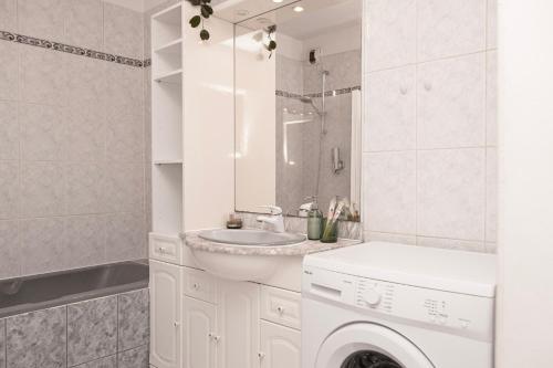 a white bathroom with a sink and a washing machine at Appartement Cosy Case 6 pers parking proche Disney et Paris in Champs-sur-Marne
