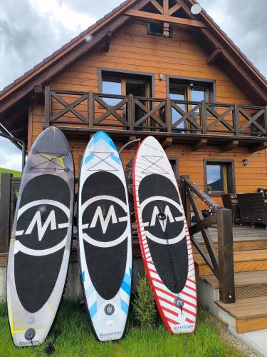 three surfboards are leaned up against a cabin at Chata Valeriana Liptov in Ižipovce