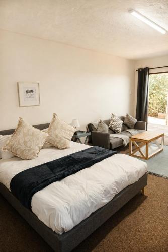 a bedroom with a large bed and a couch at Idylla Guest Home in Kenton on Sea