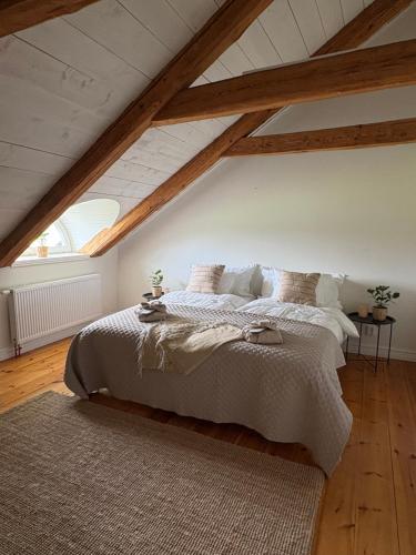 a bedroom with a large bed in a attic at Tant Märtas rum & skafferi in Köinge