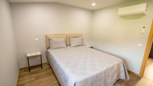a small bedroom with a bed and a night stand at Casa da Moura - Arcos de Valdevez in Arcos de Valdevez