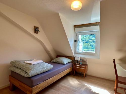 a small attic room with a bed and a window at Goldner Stern Kaub in Kaub
