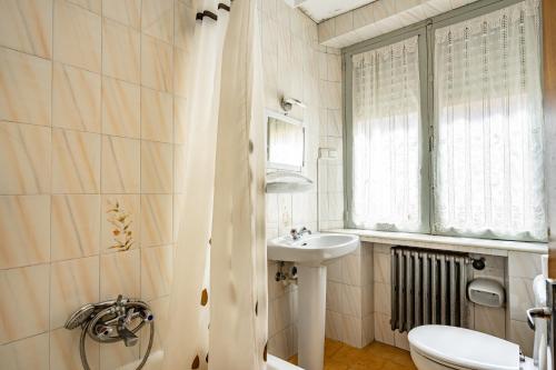 a bathroom with a sink and a toilet and a window at Hostal Oria in Luarca
