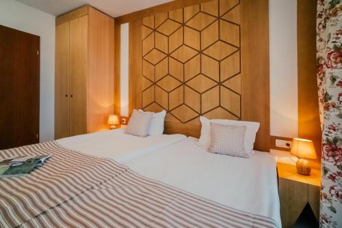 a bedroom with a large white bed with two pillows at Green Life Bansko in Bansko