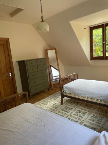 a bedroom with two beds and a dresser and a mirror at La Bruyere in Saint-Pois