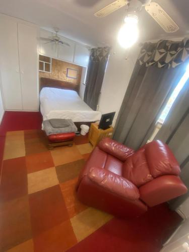 a room with a bed and a leather couch at A Spacious Odyssey in Dagenham