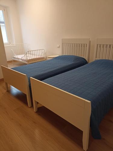 two beds with blue sheets in a bedroom at Maria in Palmanova