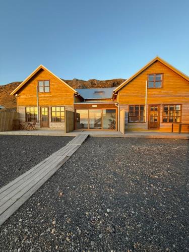 a large wooden house with a driveway in front of it at Malarhorn Accommodations in Drangsnes
