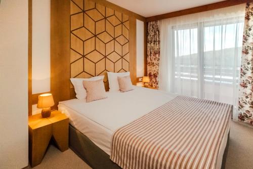 a bedroom with a large bed with a window at Green Life Bansko in Bansko