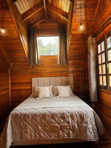 a bedroom with a large bed with a window at Refúgio Da Lua - Celeiro in Ametista do Sul