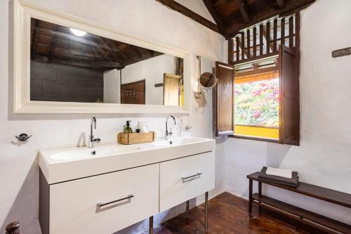 a bathroom with a sink and a mirror and a window at Casa la Moringa in Los Silos