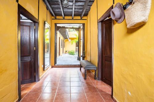 a hallway with yellow walls and a bench in a hallway at Casa la Moringa in Los Silos