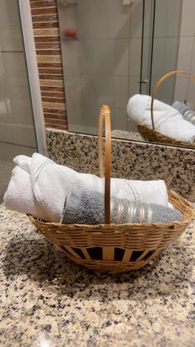 a basket of towels on a counter in a bathroom at Flat Aconchegante Hotel Intercity Manaus in Manaus