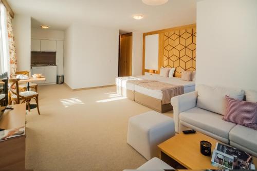 a hotel room with two beds and a couch at Green Life Bansko in Bansko