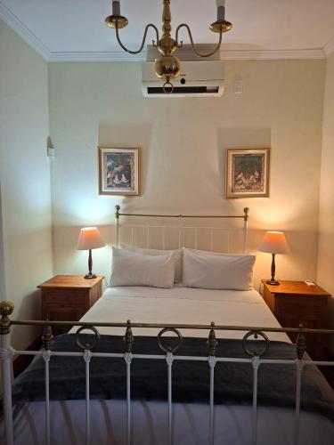 a bedroom with a bed with two night stands and two lamps at De Kothuize 6 in Graaff-Reinet