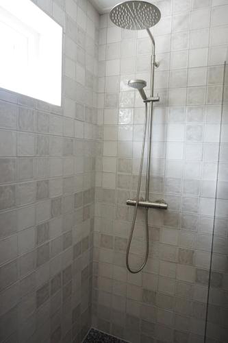 a shower with a shower head in a bathroom at Kustverhuur, 't Uusje Nieuwvliet in Nieuwvliet