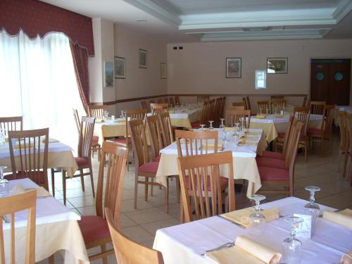 a dining room with tables and chairs with white tablecloths at Hotel Margherita in San Giovanni Rotondo