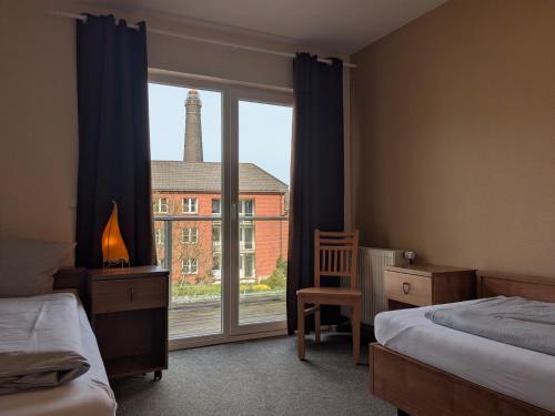 a bedroom with two beds and a large window at Suite Hotel Villa Erika in Borkum
