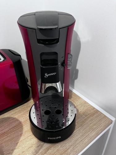 a black and red coffee maker sitting on a table at Le Balcon in Frazé
