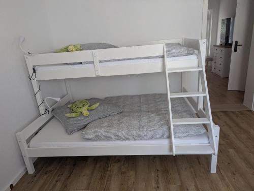 a white bunk bed with two stuffed monkeys on it at Gute Stube - Ferienhaus NaheZeit Bostalsee in Nohfelden